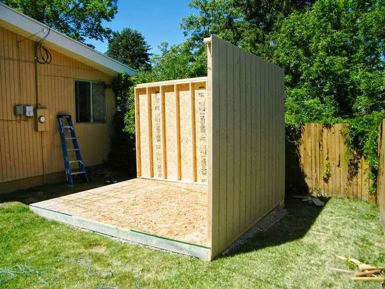 Partially assembled backyard shed kit with labeled steel panels