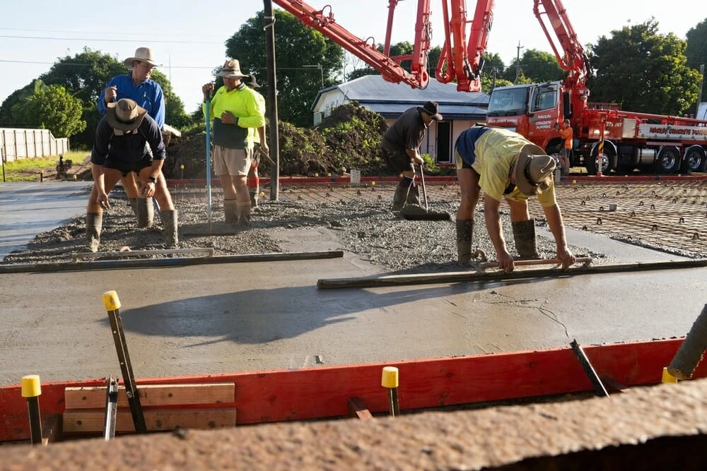 Professionals preparing a concrete slab for a new shed